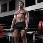 Shirtless man deadlifting heavy weight