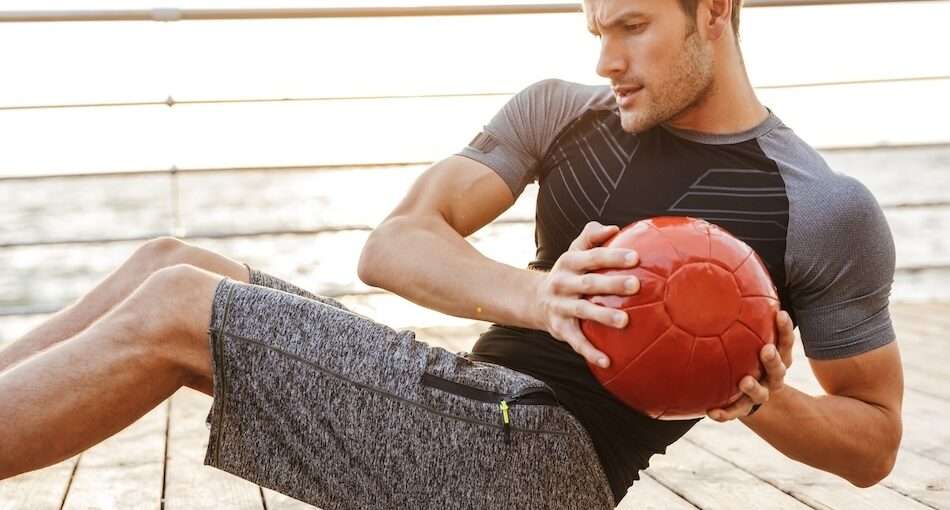man working out with a weight ball on deck