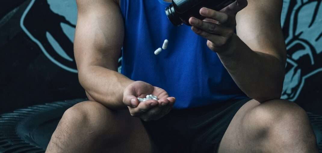 A man taking low-stim pre-workout supplements.