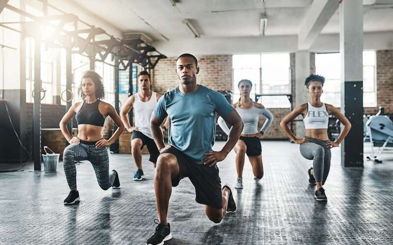 A group of diverse people working out together in a building.
