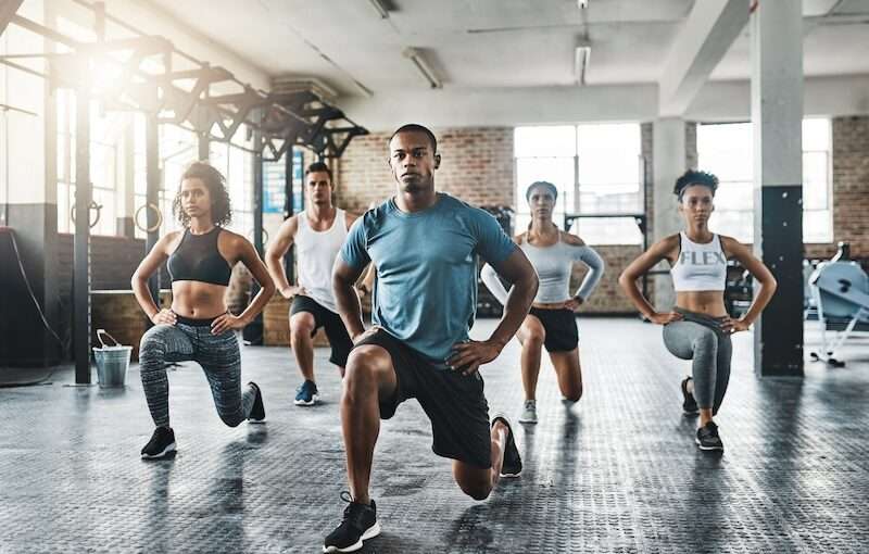 A group of diverse people working out together in a building.