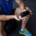 A man pouring prohormone pills into his hand at the gym