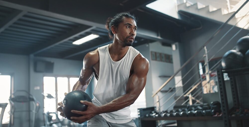 A strong man at the gym working out with weighted ball